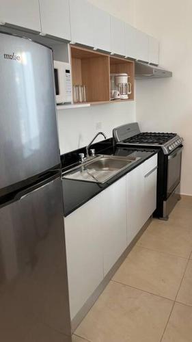 a kitchen with a stainless steel refrigerator and a sink at Casa de Descanso y Aventuras en zona privada in Mérida