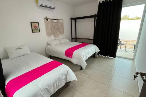 two beds in a room with a view of the ocean at Casa de Descanso y Aventuras en zona privada in Mérida