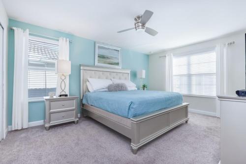 a bedroom with a bed with blue walls and windows at Luxury Home inside Champions Gate - No Extra Fees in Davenport
