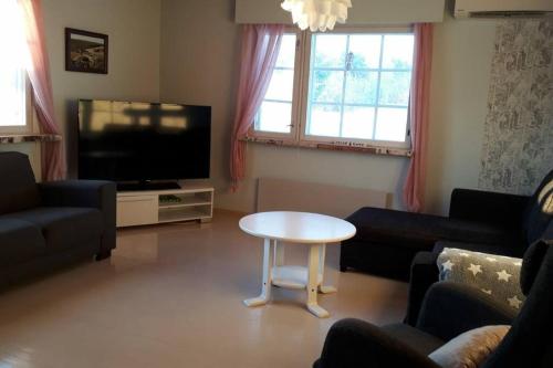 sala de estar con mesa y TV en Vanha maalaistila, en Kuhmo