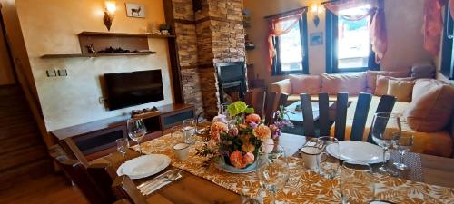 a dining room table with a vase of flowers on it at Guest House Chepelare in Chepelare