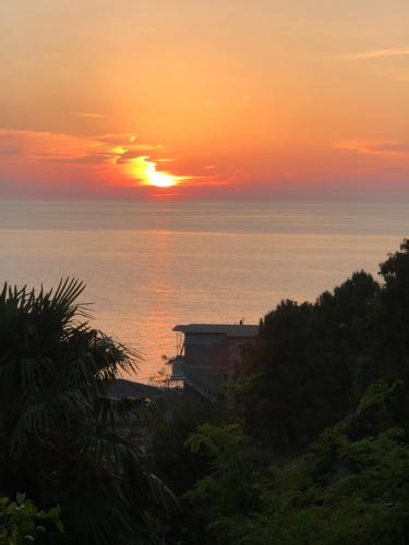 a sunset over the ocean with the sun in the sky at Старый дом! in Chakvi