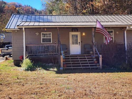 a small house with an american flag in front of it at 2 bed, 1.5 bath cottage across from Watauga Lake in Butler