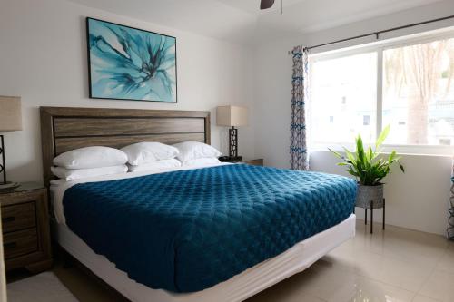 una camera da letto con un letto con un piumone blu di Sandpiper Apartments a Mount Pleasant