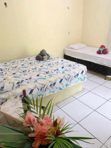 een slaapkamer met 2 bedden en een tafel met bloemen bij Suite Apoena 1 in Pacoti