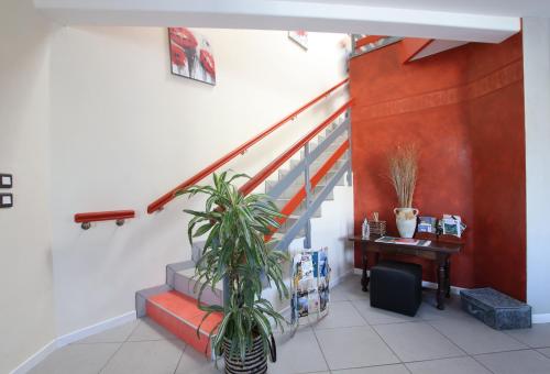 a hallway with a staircase with a plant and a table at Les 3 Edelweiss - GITE 1 OU GITE 2 in Arette