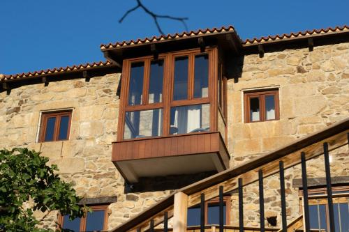 a window on the side of a stone building at Ecolagar O Barqueiro in Pantón
