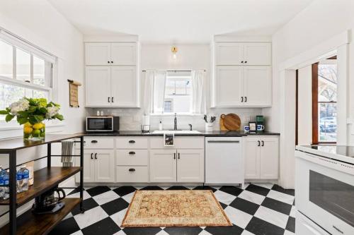 a kitchen with white cabinets and a checkered floor at Downtown Bungalow with Geothermal Hot Spring in Boise
