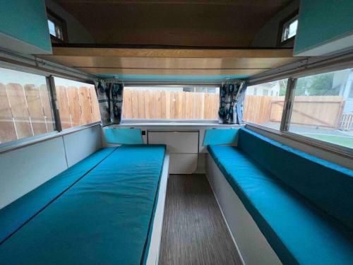 a empty train room with blue seats and windows at Downtown Bungalow with Geothermal Hot Spring in Boise