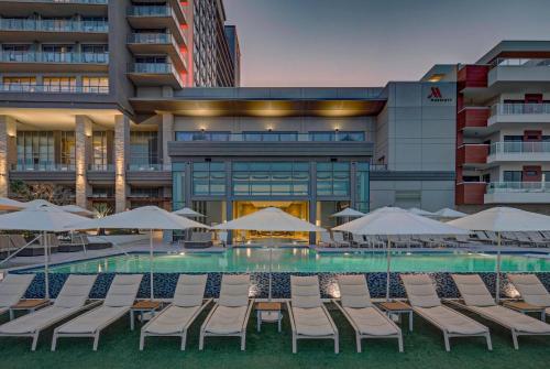 a pool with chairs and umbrellas in front of a building at Marriott Virginia Beach Oceanfront Resort in Virginia Beach