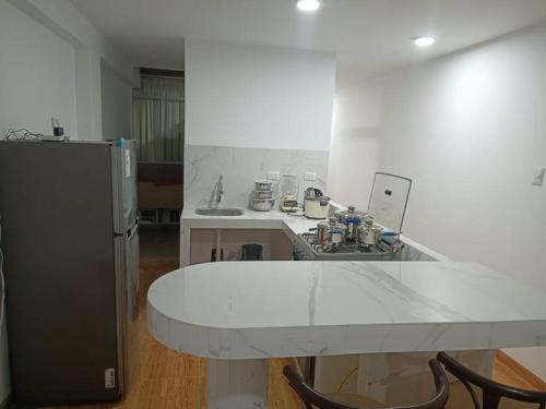 a kitchen with a white counter top and a refrigerator at Apartamentos Cristo Rey. in Tacna