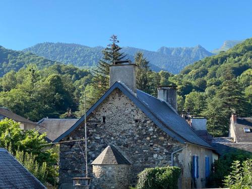 an old stone building with a chimney on top of it at Appartement Familial in Marignac
