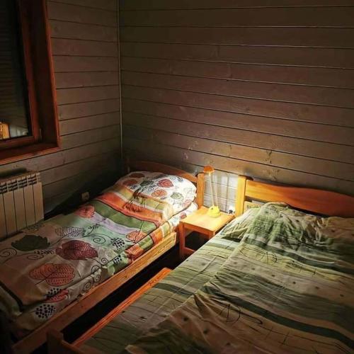 a room with two beds and a table with a bedskirts at Vila Treska 98 in Kopaonik