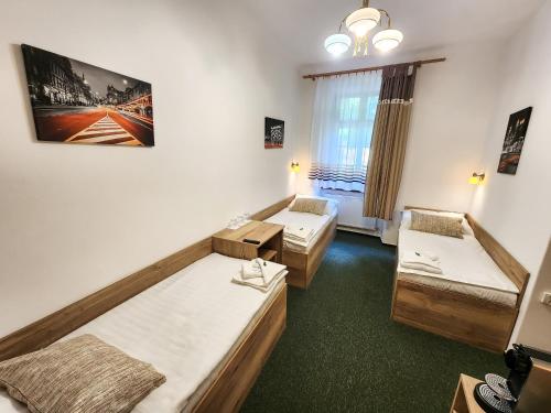 a hotel room with two beds and a window at Pension City in Pilsen