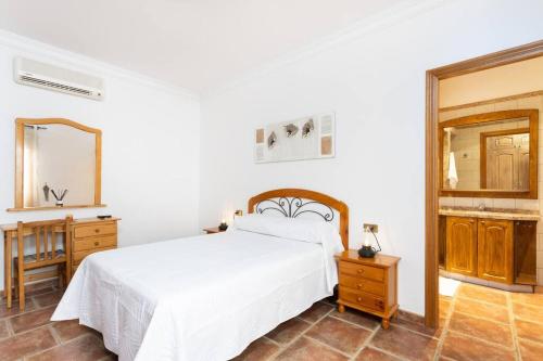 1 dormitorio con cama blanca y espejo en El Retamar, naturaleza y paisajes en Santiago del Teide
