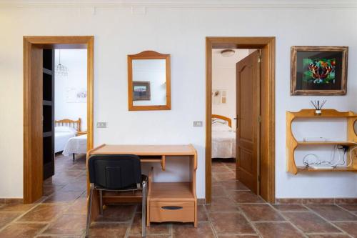 a room with a wooden desk and a bedroom at El Retamar, naturaleza y paisajes in Santiago del Teide