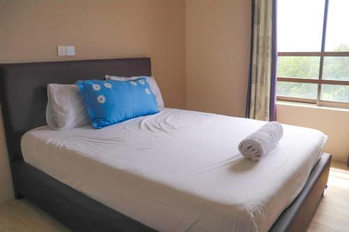 een bed met een handdoek en een raam bij Kamande Ocean Breeze in Pingilikani