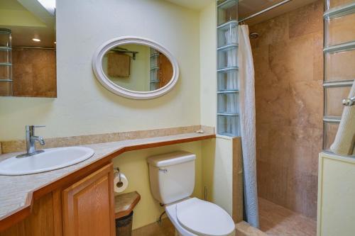 a bathroom with a toilet and a sink and a mirror at Sunny Waianae Condo with Ocean View! in Waianae