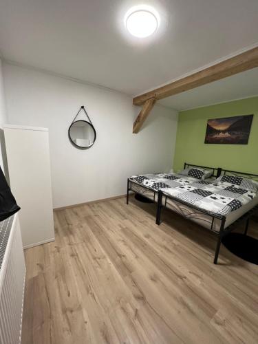 a bedroom with a bed and a wooden floor at Ferienwohnung Pfaffensteinblick in Hirschbach