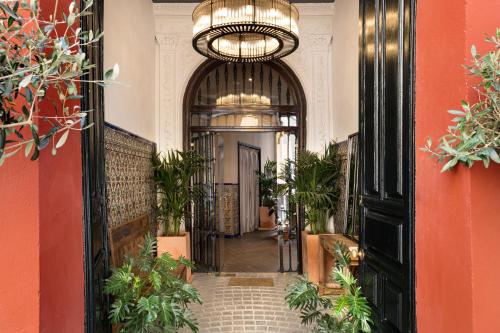 uma entrada para um edifício com um corredor com plantas em The Honest Hotel em Sevilha