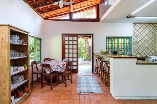una cucina con un tavolo e sedie in una stanza di itamambuca condominio - Cabana Surf a Ubatuba