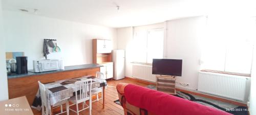 ein Wohnzimmer mit einem roten Sofa und einem TV in der Unterkunft Superbe appart cosy, bien situé avec une chambre in Denain