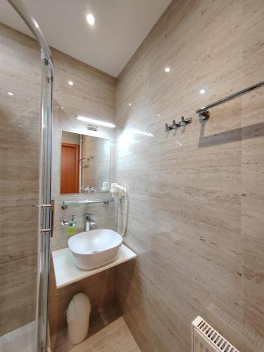 a bathroom with a sink and a shower at Rooms Lidija in Zagreb