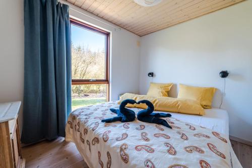 a bedroom with a bed with two blue snakes on it at Vidunderlig fritidshus ved Skov og Golfbane in Skjern