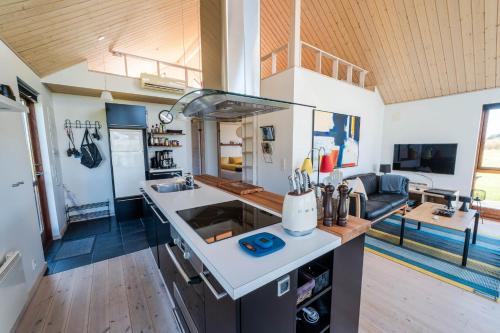 a kitchen and living room with a couch in the background at Vidunderlig fritidshus ved Skov og Golfbane in Skjern