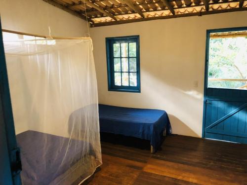 a bedroom with a bed in a room with a window at Casa da Roça- Casa completa e jardim privativo in Mata de Sao Joao