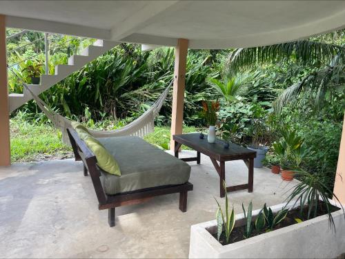 a porch with a hammock and a table at Casa Jaguar Tortuguero in Tortuguero