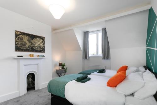 Dormitorio blanco con cama y chimenea en Large 4 bed house Leicester, en Leicester