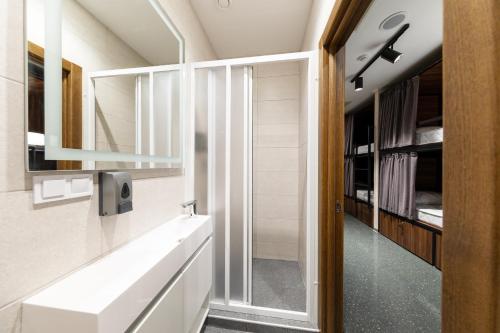 a bathroom with a white sink and a mirror at MISTO capsule hotel in Kyiv
