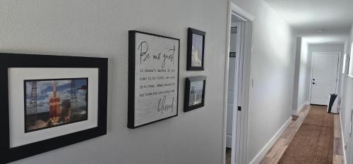 a hallway with four framed pictures on a wall at Nasa waterfront Dolphin Suite in Titusville