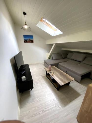 uma sala de estar com um sofá e uma mesa em Charmant studio plein centre em Saint-Gaudens
