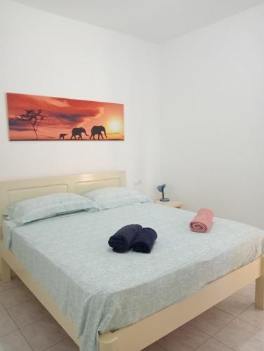 een slaapkamer met een bed met twee hoeden erop bij VIOLA in Vila do Maio