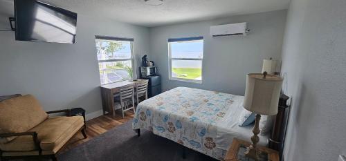 ein Schlafzimmer mit einem Bett, einem Stuhl und einem Fenster in der Unterkunft Nasa waterfront Dolphin Suite in Titusville