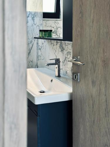 a bathroom with a white sink and a mirror at Alexandra's Place in Galatás