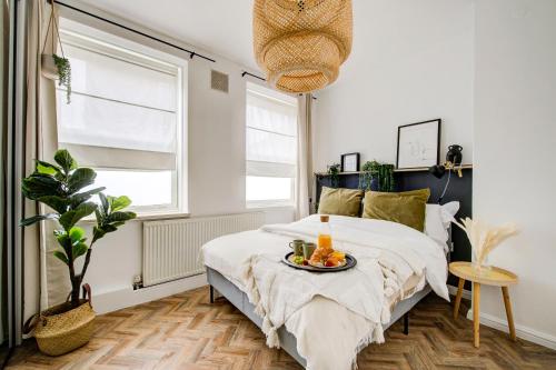 a bedroom with a bed with a tray of fruit on it at Beautiful 2bedroom close to Brick Lane in London