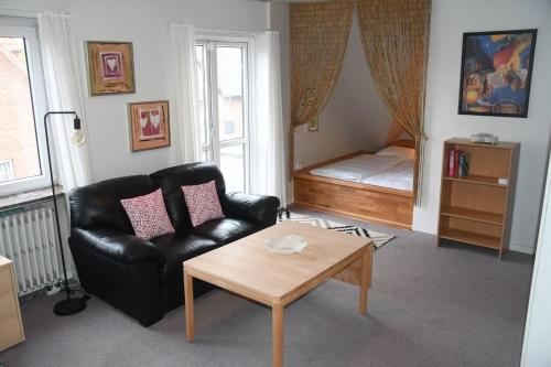 sala de estar con sofá de cuero negro y mesa en Lovely 2-Bed Apartment in townhouse in Gram en Gram