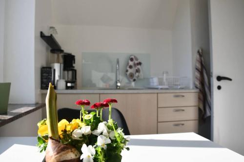 una cocina con una mesa con un jarrón de flores. en Lovely 2-Bed Apartment in townhouse in Gram en Gram