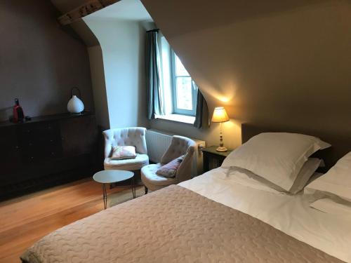 - une chambre avec un lit, une chaise et une fenêtre dans l'établissement Het Oud Gemeentehuis-De Levensboom, à Damme
