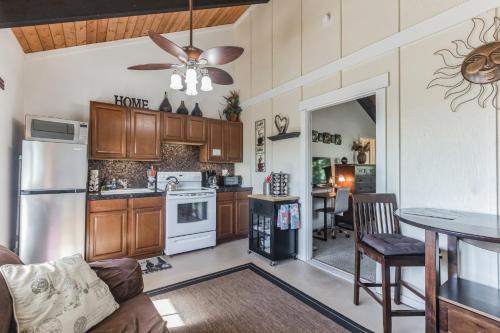 una cocina con armarios de madera y una mesa con ventilador de techo. en Cozy Sunset Views with Lanai - Close to Beach home, en Kailua-Kona