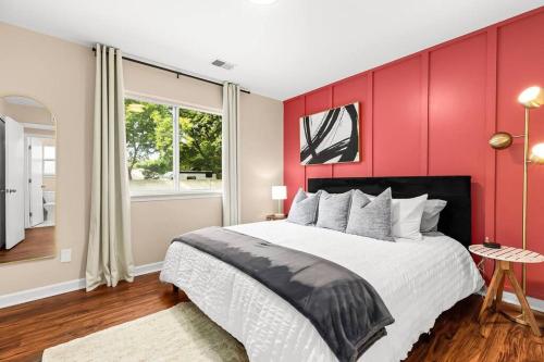 a bedroom with a large bed with red walls at New! Comfy Flat near Downtown Roseville in Roseville