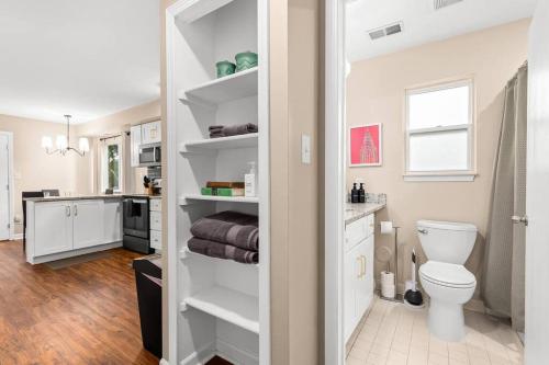 a bathroom with a toilet and a kitchen at New! Comfy Flat near Downtown Roseville in Roseville