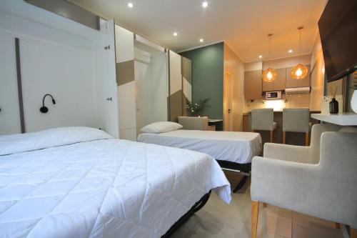 ポサーダスにあるHuellas - Boutique Apartmentsのベッド2台とダイニングエリアが備わるホテルルームです。