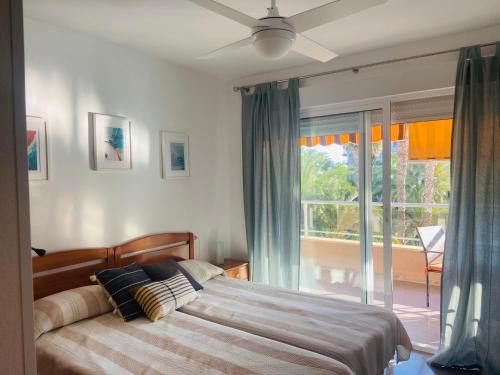 ein Schlafzimmer mit einem Bett und einem großen Fenster in der Unterkunft Green Palmeral Los Locos Torrevieja in Torrevieja