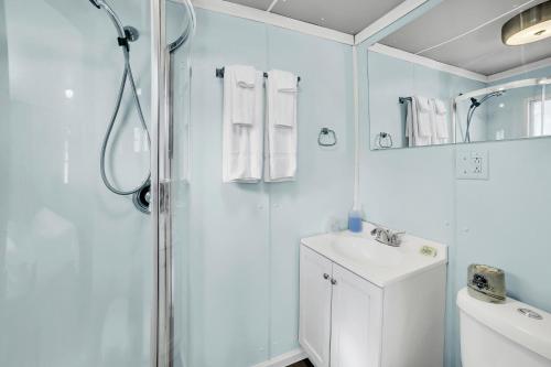 a white bathroom with a shower and a sink at Eagles Nest Motel Unit 2 in Escanaba