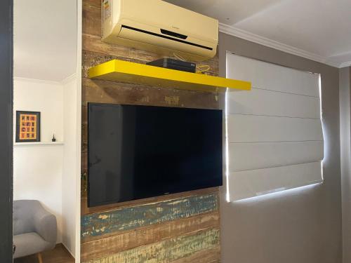 telewizor z płaskim ekranem wiszący na ścianie w obiekcie Studio Minimalista Região Central Residencial Padre Kolb 201C w mieście Joinville