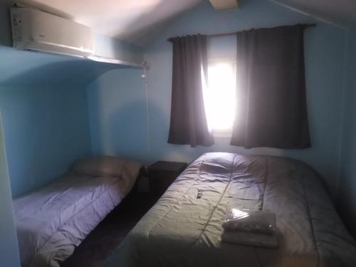ein kleines Zimmer mit 2 Betten und einem Fenster in der Unterkunft Lo de Juan in Godoy Cruz